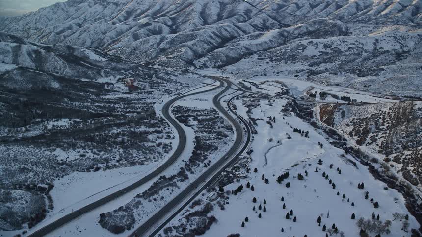 An aerial view of an intersection of some streets in a rural region with snow on the ground