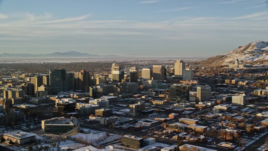Aerial panorama of a metropolis surrounded by snowcovered mountains in the morning
