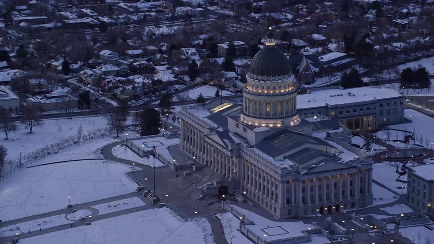 Snow covers grounds of government buildings and nearby neighborhood on dim day
