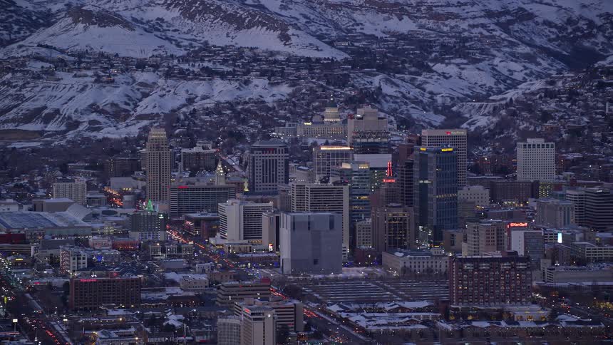 Aerial view of a city in the snowcovered mountains lit up at dusk