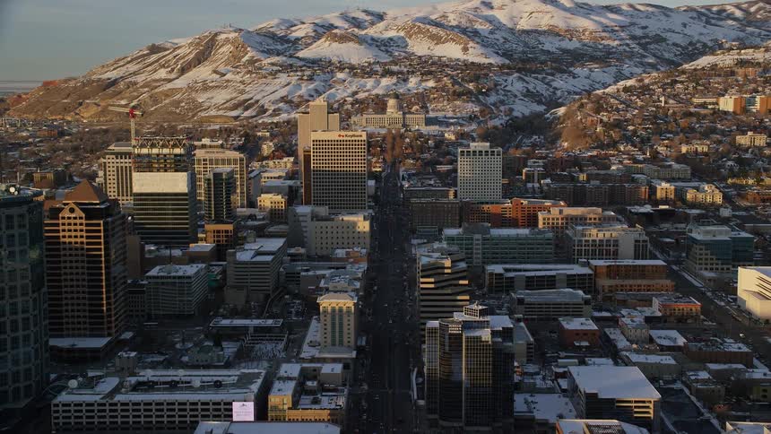 A snow covered mountain is behind the city