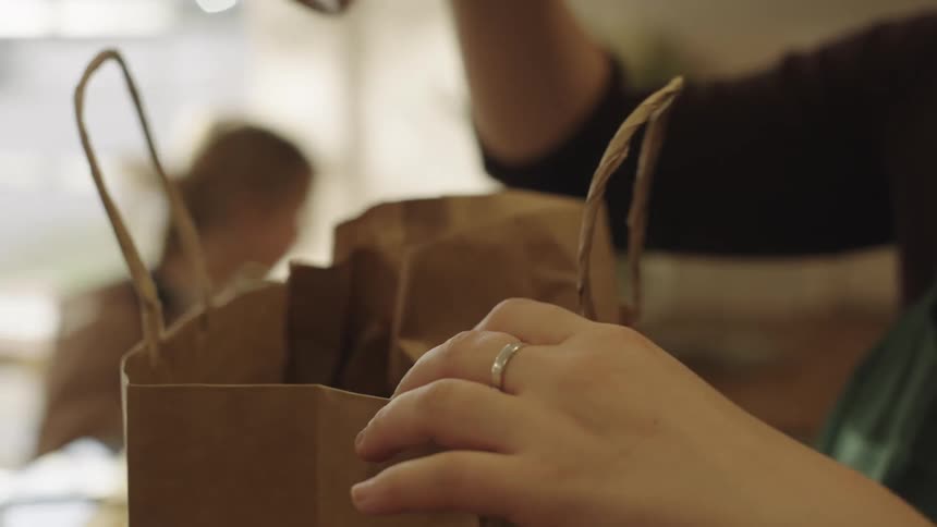 Close up of a cashier bagging groceries at the shop