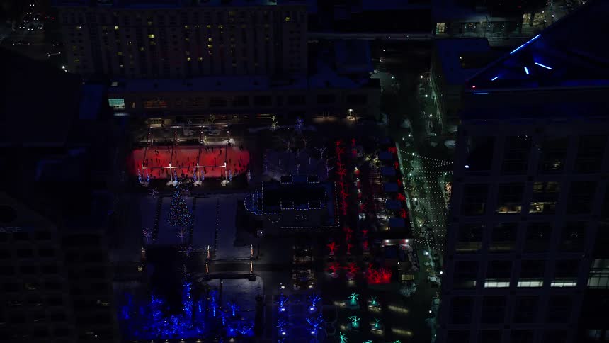 Snow skating rink amidst a metropolis at night
