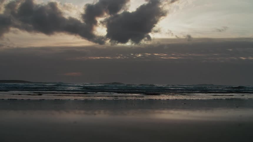 Waves hitting the beach during sunset