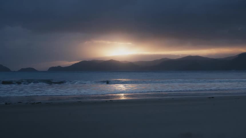 A still shot of the tide at a beach at sunset