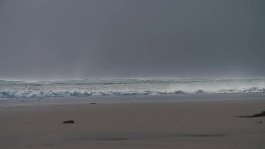 Ocean waves breaking against the beach