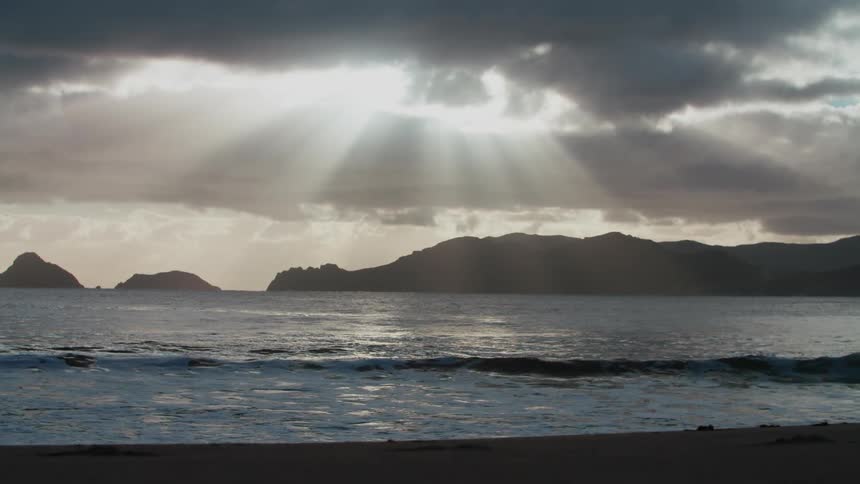 Panorama of the beach with calm waves and the coastline on the horizon under a morning sky