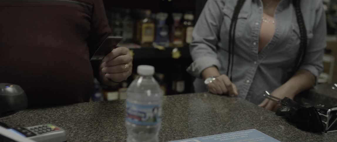 A woman hands a photograph to people working in a store