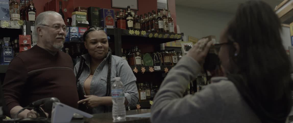 Two people behind a store counter have their picture taken