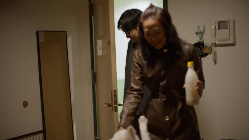 A couple who arrive home are happily greeted by their dog
