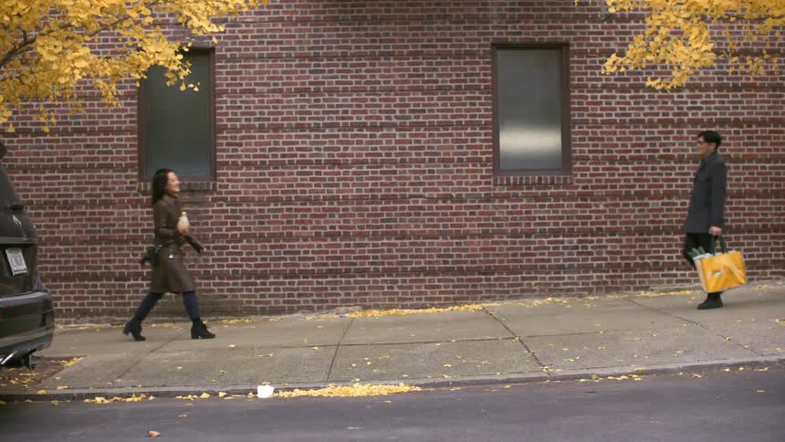 Couple meeting on the sidewalk hugging and continuing to walk together