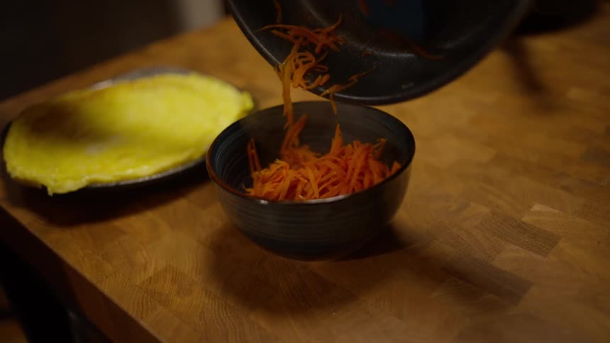 A person placing a portion of food into a bowl