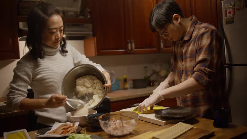 Asian man and woman preparing food at the kitchen counter at home