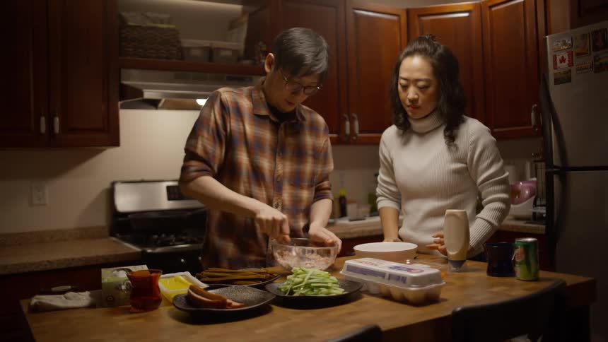 A couple mixing ingredients for a meal