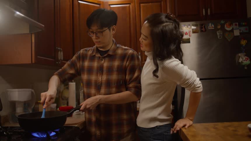 A man mixing ingredients for a meal in a pot on the stove