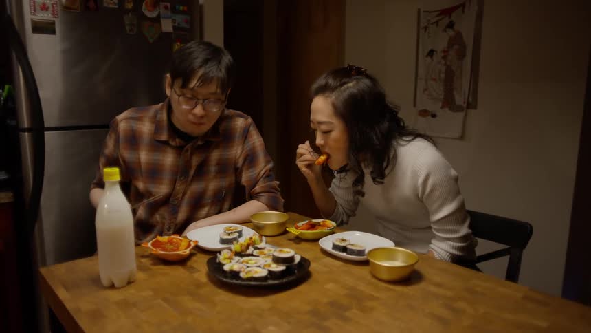 A man and woman have dinner together at home