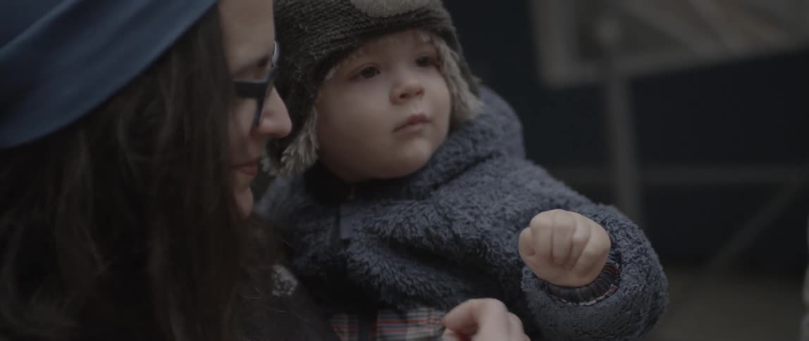 A woman and child hold up peace signs briefly
