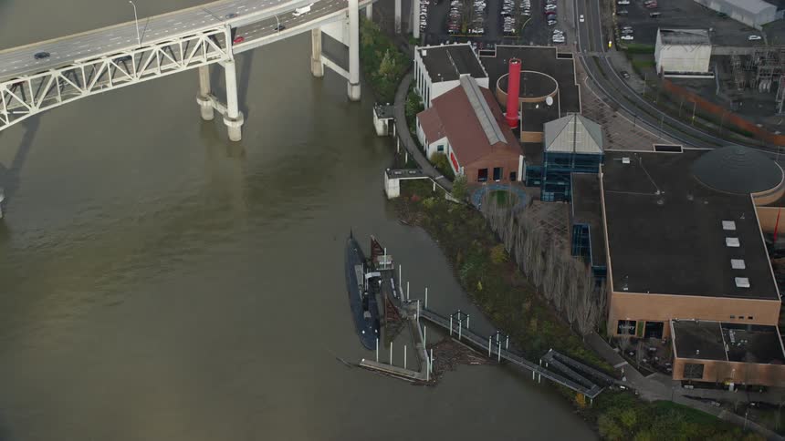 Aerial panorama of a boat moored on the lake next to a city with a bridge