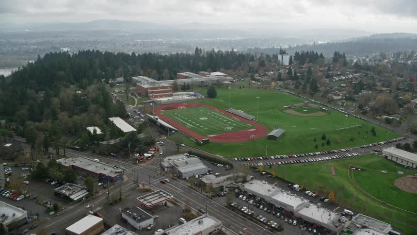 Aerial panorama of an urban city with a university and fields on a cloudy day