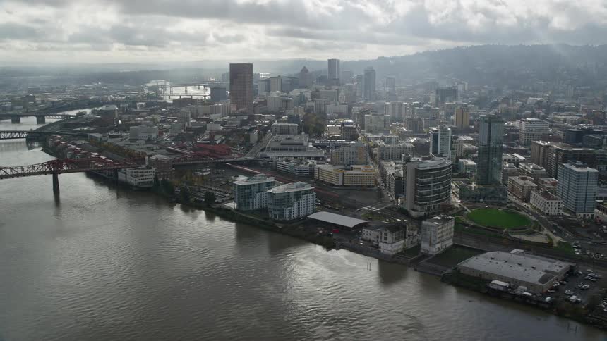 A city with a bridge and a river is shown in the aerial view