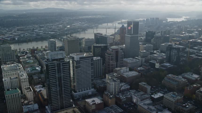 Aerial shot of a large city with several buildings and a river on a sunny day