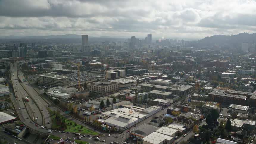 Aerial view of a large city with numerous buildings houses and warehouses on a cloudy and sunny day