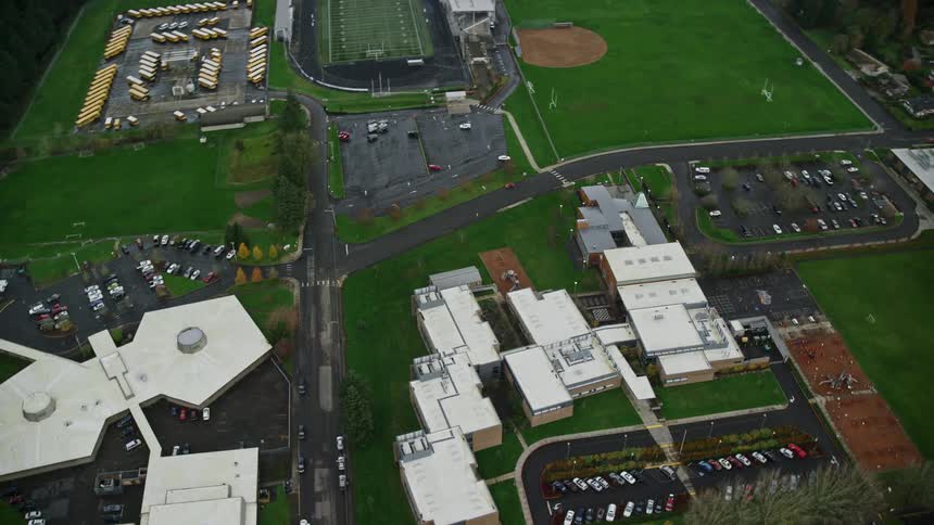 An aerial view of a field with some buildings and a large lawn
