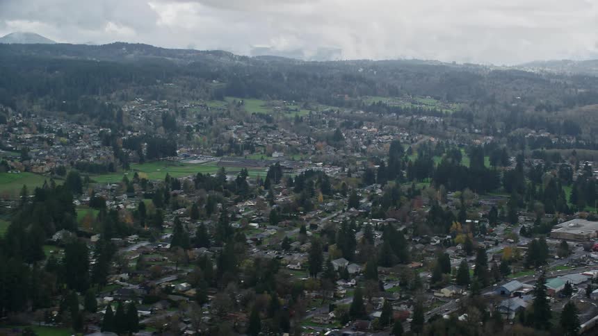 Aerial panorama of an urban city amidst mountains on a cloudy day