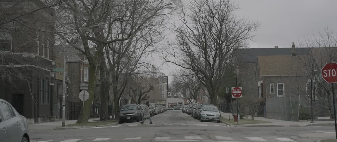 A tow truck drives by a woman crossing the street