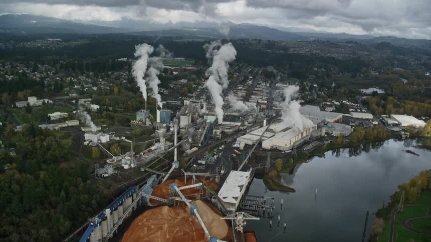Aerial of a factory on the banks of the river in the suburbs