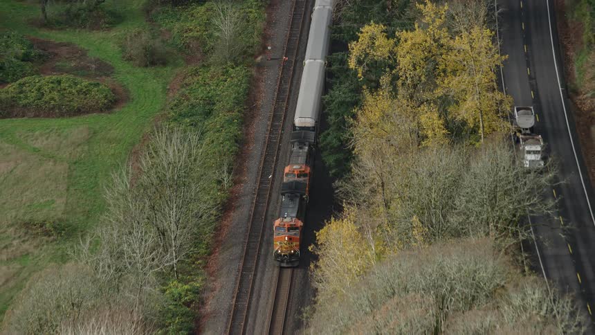 Train passing by next to a highway