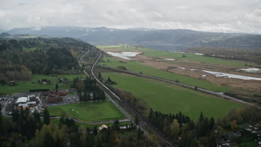 Aerial panorama of an urban city nestled among mountains roads and lakes
