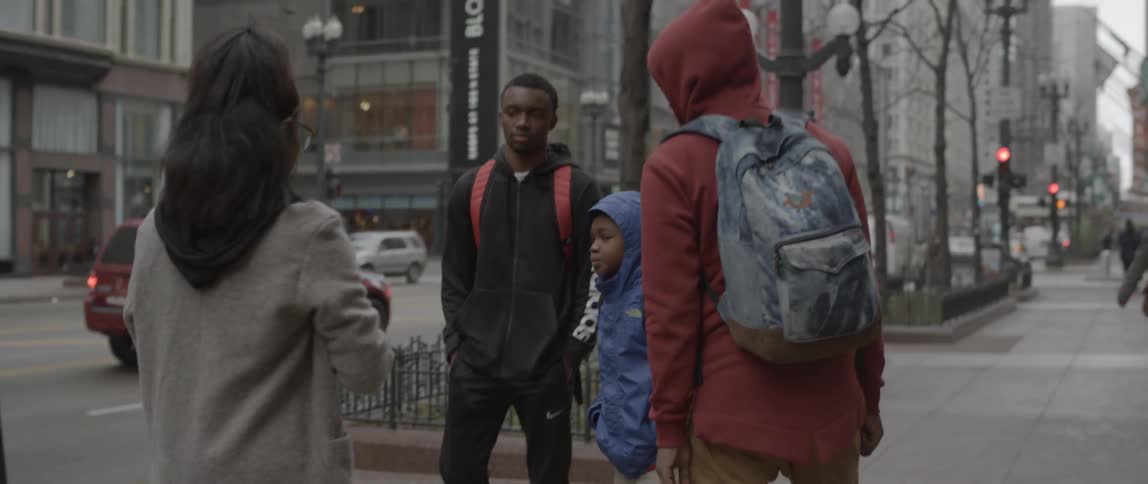 A group of boys pose for a photograph on a city sidewalk