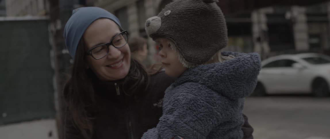 A woman smiles as she holds her child