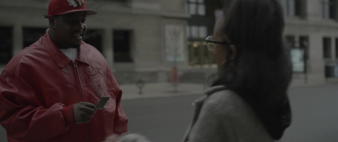 A woman hands a man a photograph and hugs him