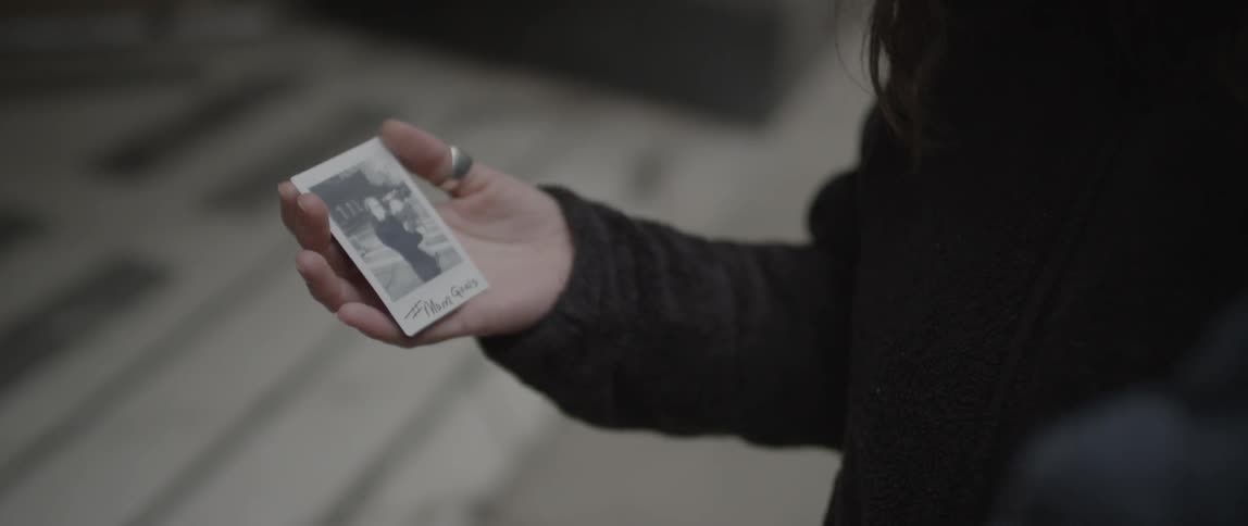 A person points at a photograph being held by another