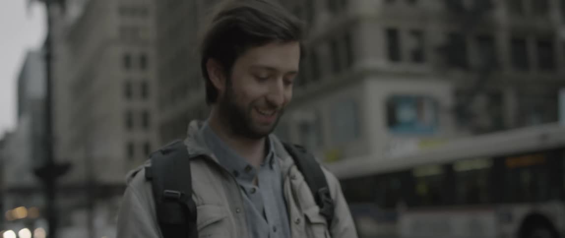 A woman hands a photograph to a man and hugs him