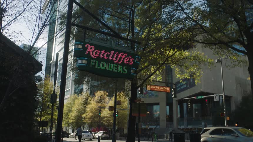 Traffic and pedestrians move past ratcliffes flower shop