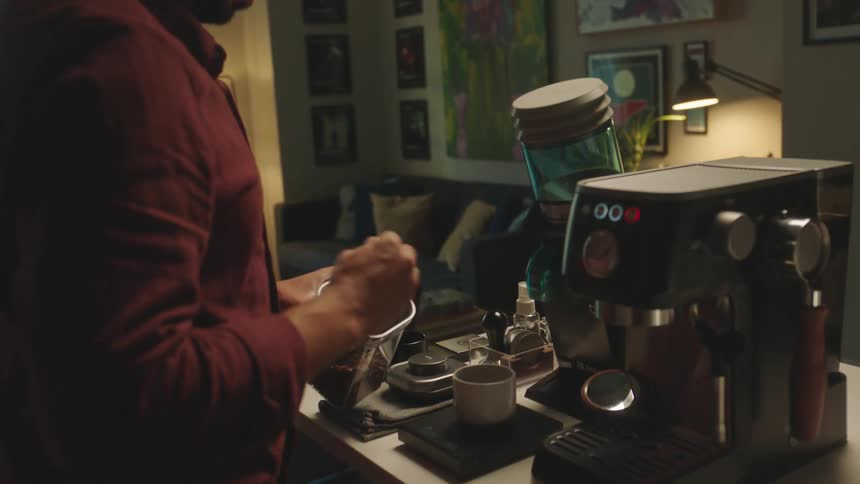 Man putting coffee powder into a cup in front of a card machine