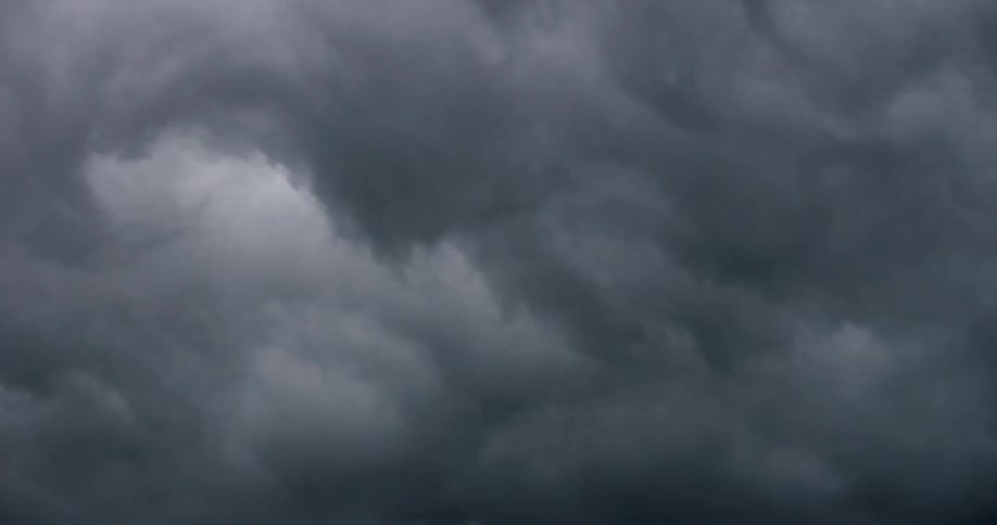 Dark clouds floating in the sky casting shadows over the landscape