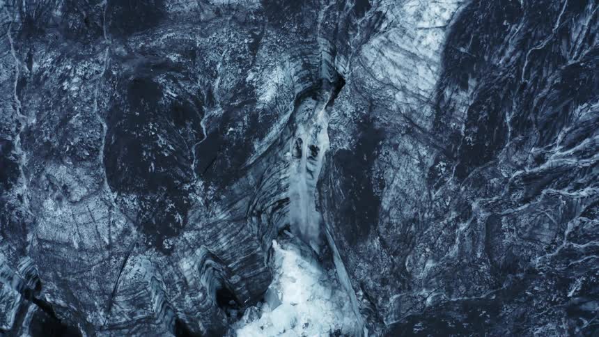 A waterfall is coming out of a glacier
