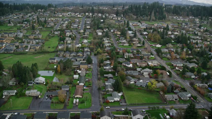 Aerial of a residential neighborhood with grassy fields during the day