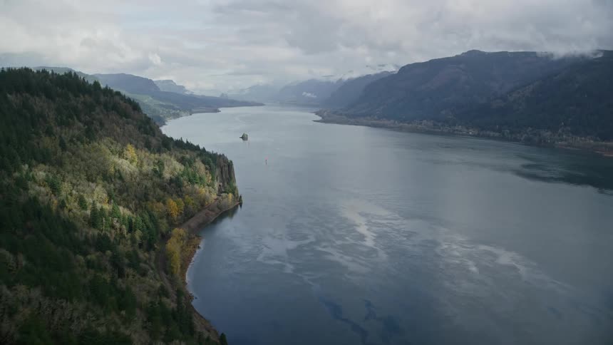 Mountains with trees around a vast lake on a cloudy day