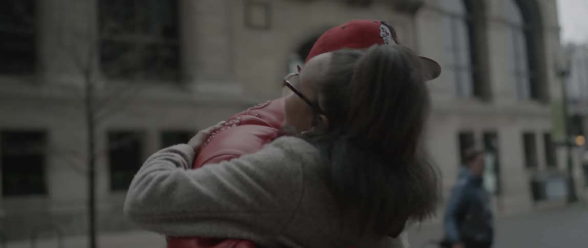 A man and woman hug on a city street