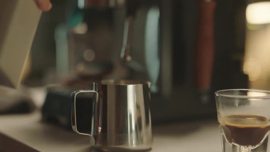 A person is pouring a liquid from a bottle into a mug