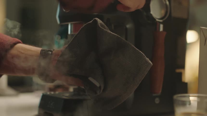 Closeup of a mans hands removing air from the coffee machine