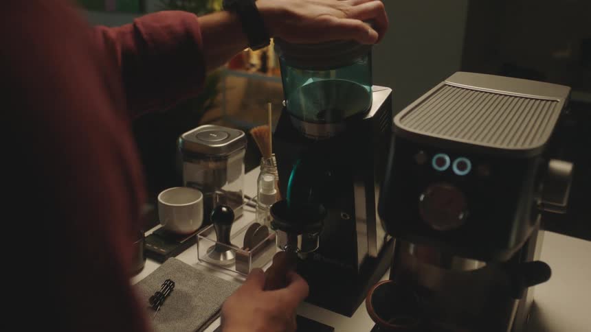 A person presses on a device thats used for making ground espresso