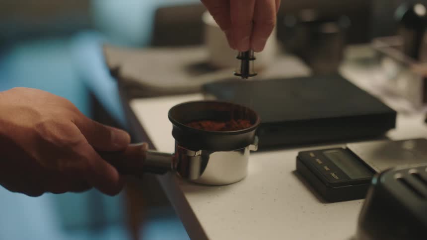 Hands of a man mixing coffee in a gauntlet