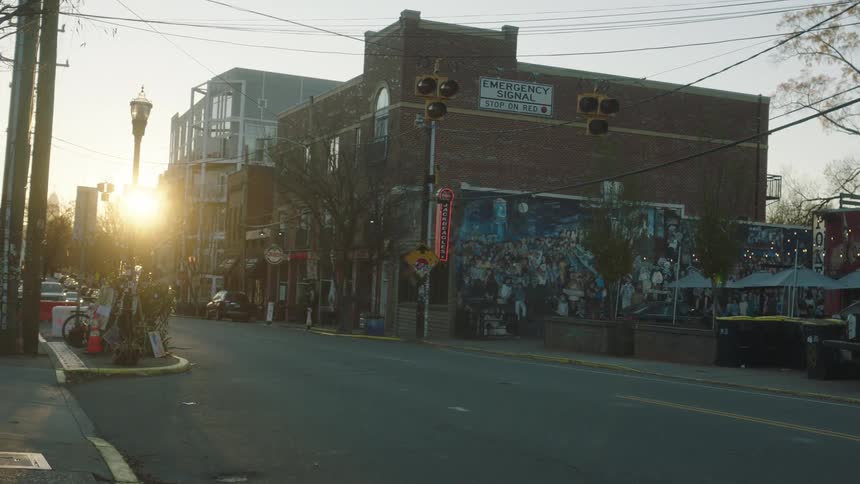 View of a city street with traffic lights and morning sunlight