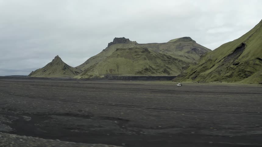 The vehicle drives past the mountains off road